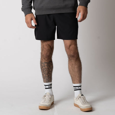 Close up image of a male models legs who is wearing a pair of JOOLA Men's Woven Short, black.