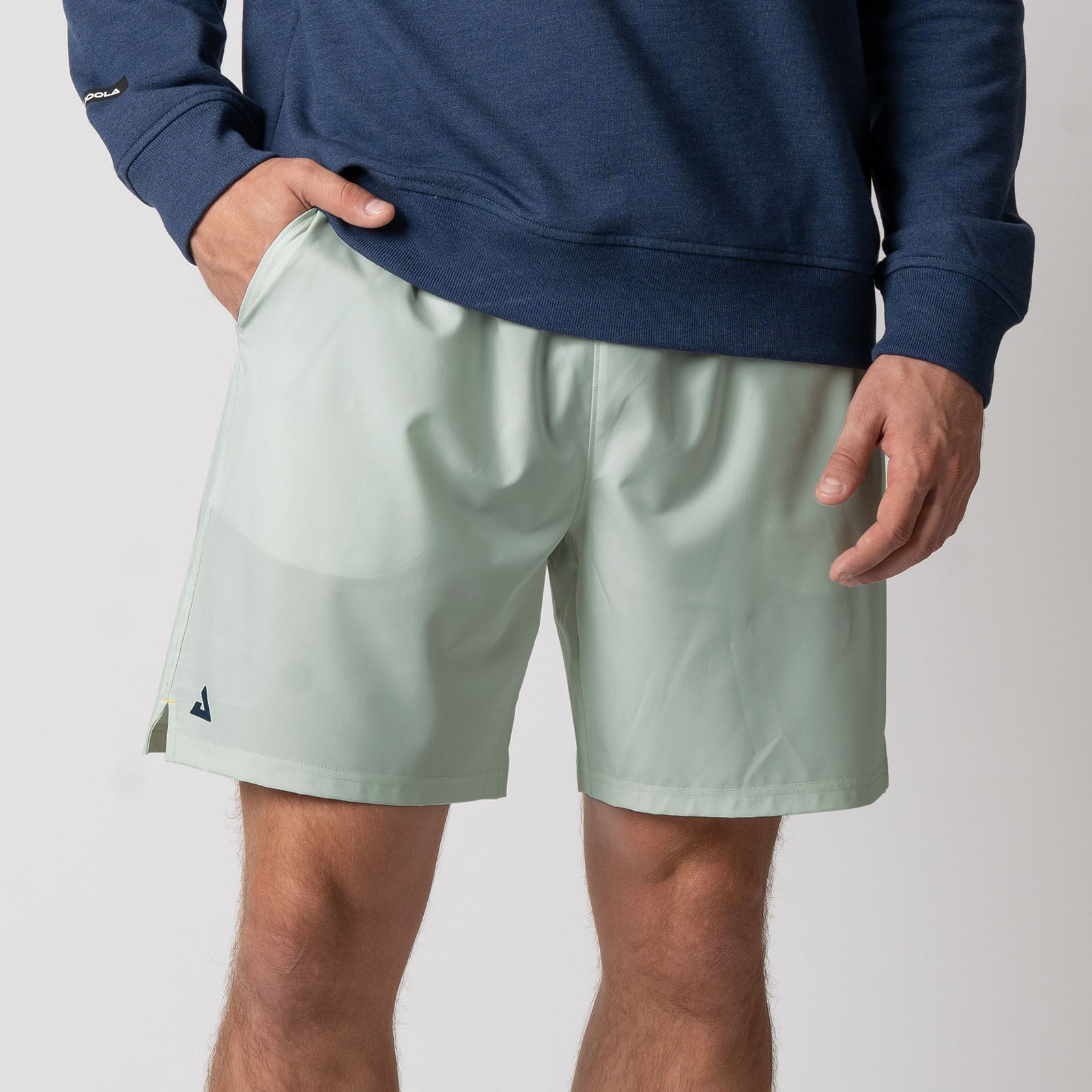 Close up image of a male model who  is wearing a pair of JOOLA Men's Woven Shorts, 7 inch inseam, hushed mint.