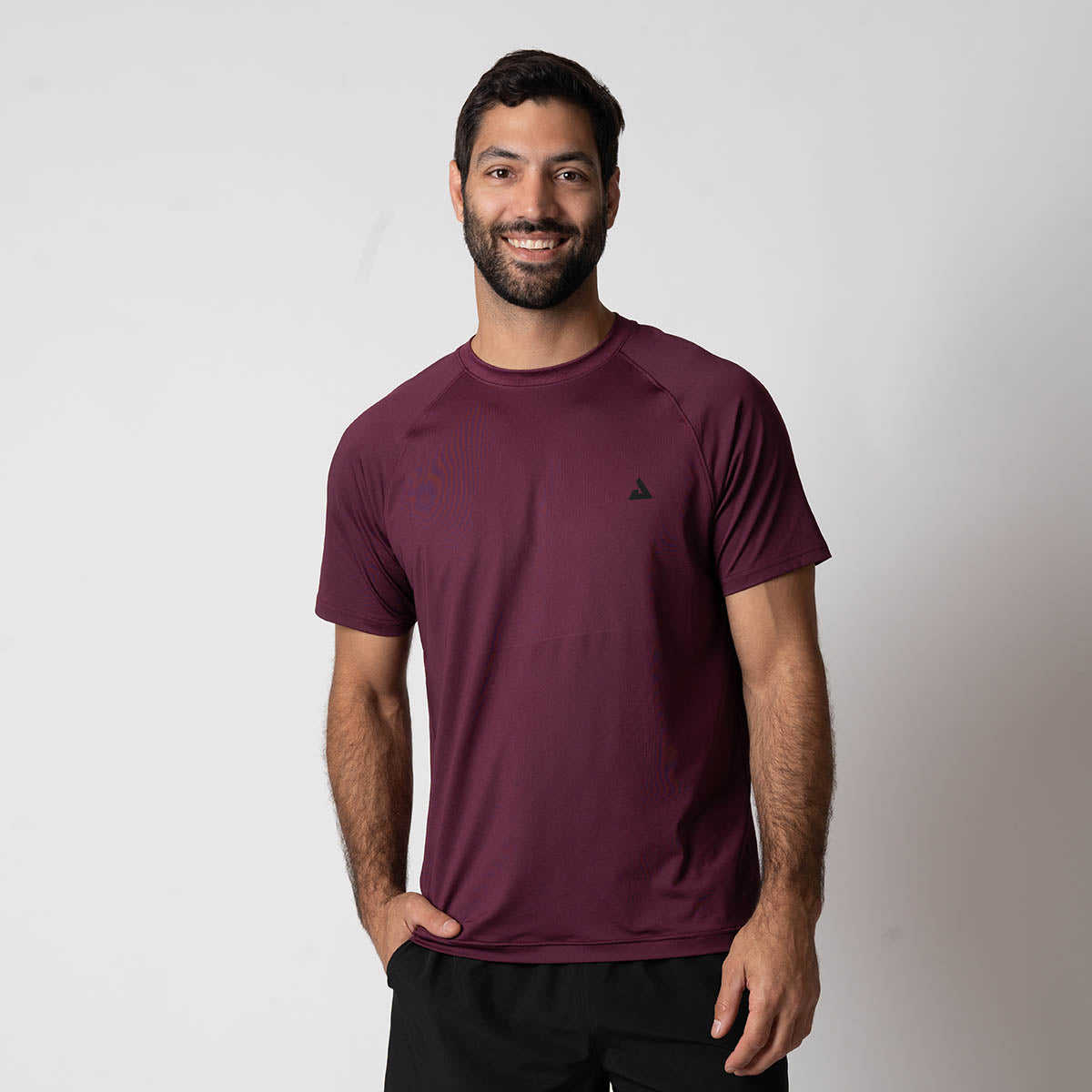 Image of a male model wearing a JOOLA men's court short sleeve shirt, Bordeaux.