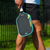 Close up on the JOOLA Power FX pickleball paddle by the legs of a male pickleball player.