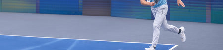 Horizontal banner image of a JOOLA athlete on a pickleball court wearing a pair of JOOLA pants.