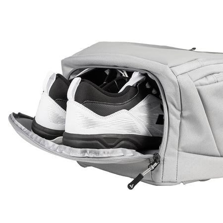 Gray shoe bag with a pair of black and white sneakers inside on a white background.