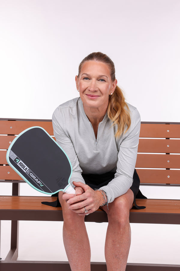 JOOLA Pro Stefanie Graf sitting on a bench with her Graf Pro V. 