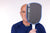 Gray background, image of Andre Agassi holding an Agassi V covering half of his face.