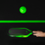 Glowing green pickleball and paddle on a black background