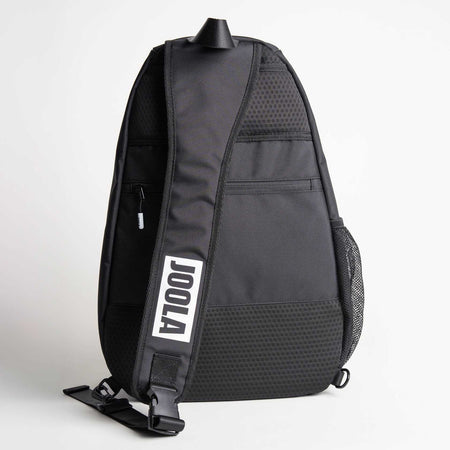 Gray background, image of the black and white JOOLA logo on the sling strap of the back pack.