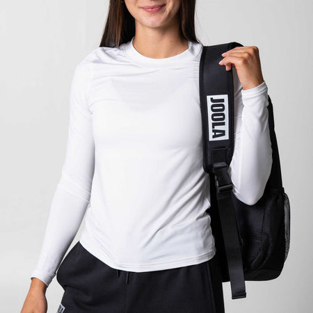 Gray background, image of a female model with a JOOLA Sling Bag over her shoulder.