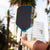 JOOLA Perseus Summer Daze Pickleball paddle with black surface, orange, blue, green and yellow color gradient on the rim, and white handle with palm trees in the background.