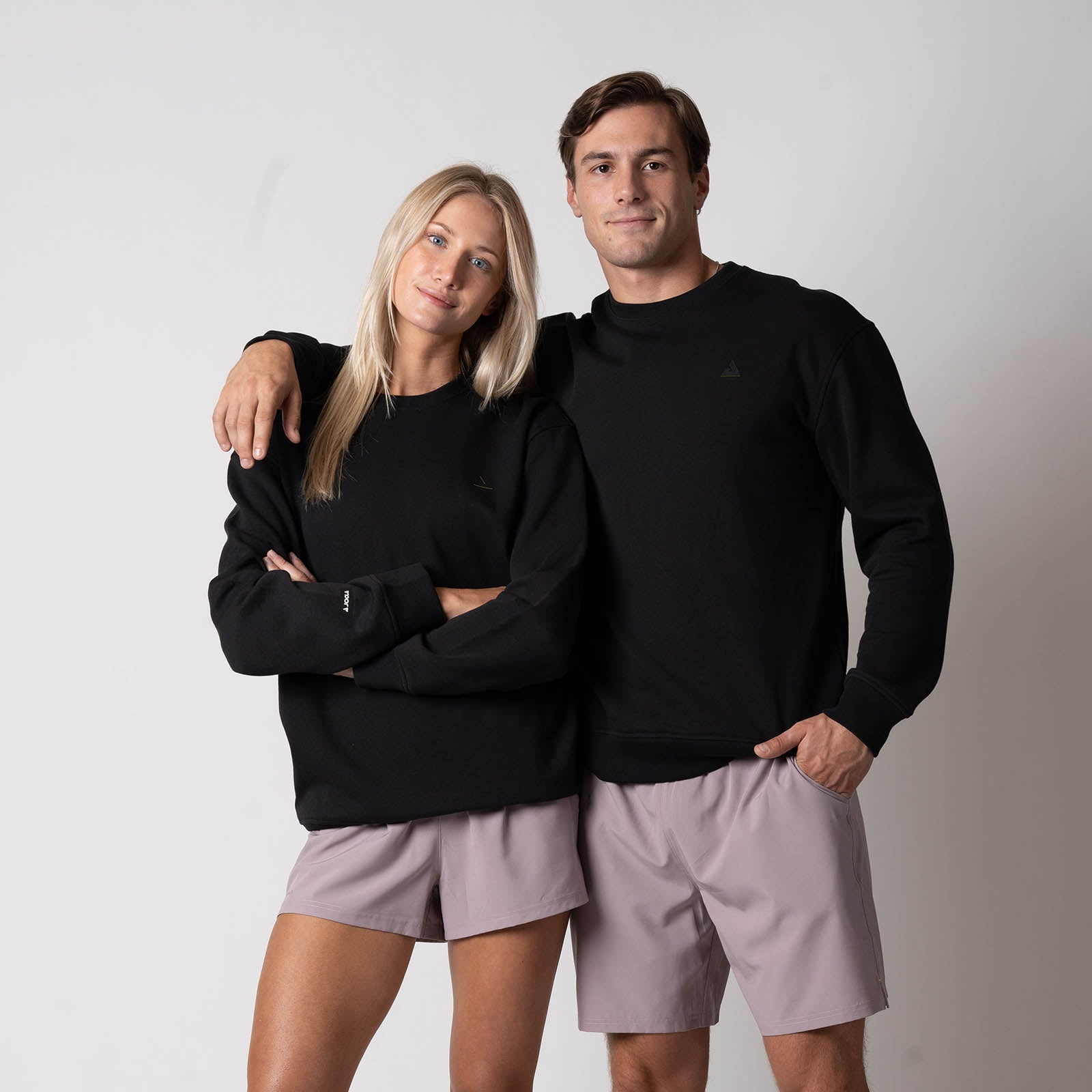 Image showing a male and female model each wearing the JOOLA Unisex Fleece Crew, Black.