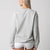 Image showing the back of a female model wearing a JOOLA Unisex Fleece Crew, Gravity Grey Heather.