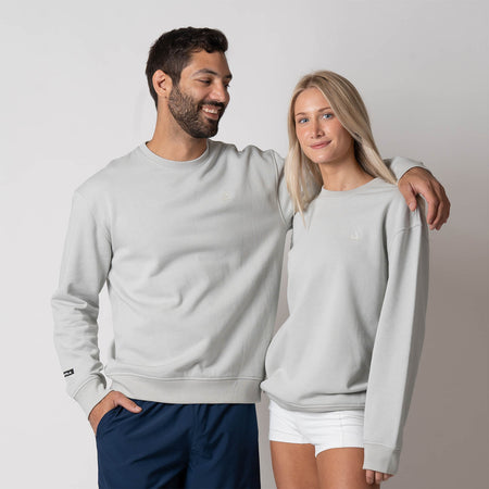 Image showing a male model with his arm around a female model, both of them are wearing a JOOLA Unisex Fleece Crew, Gravity Grey Heather.