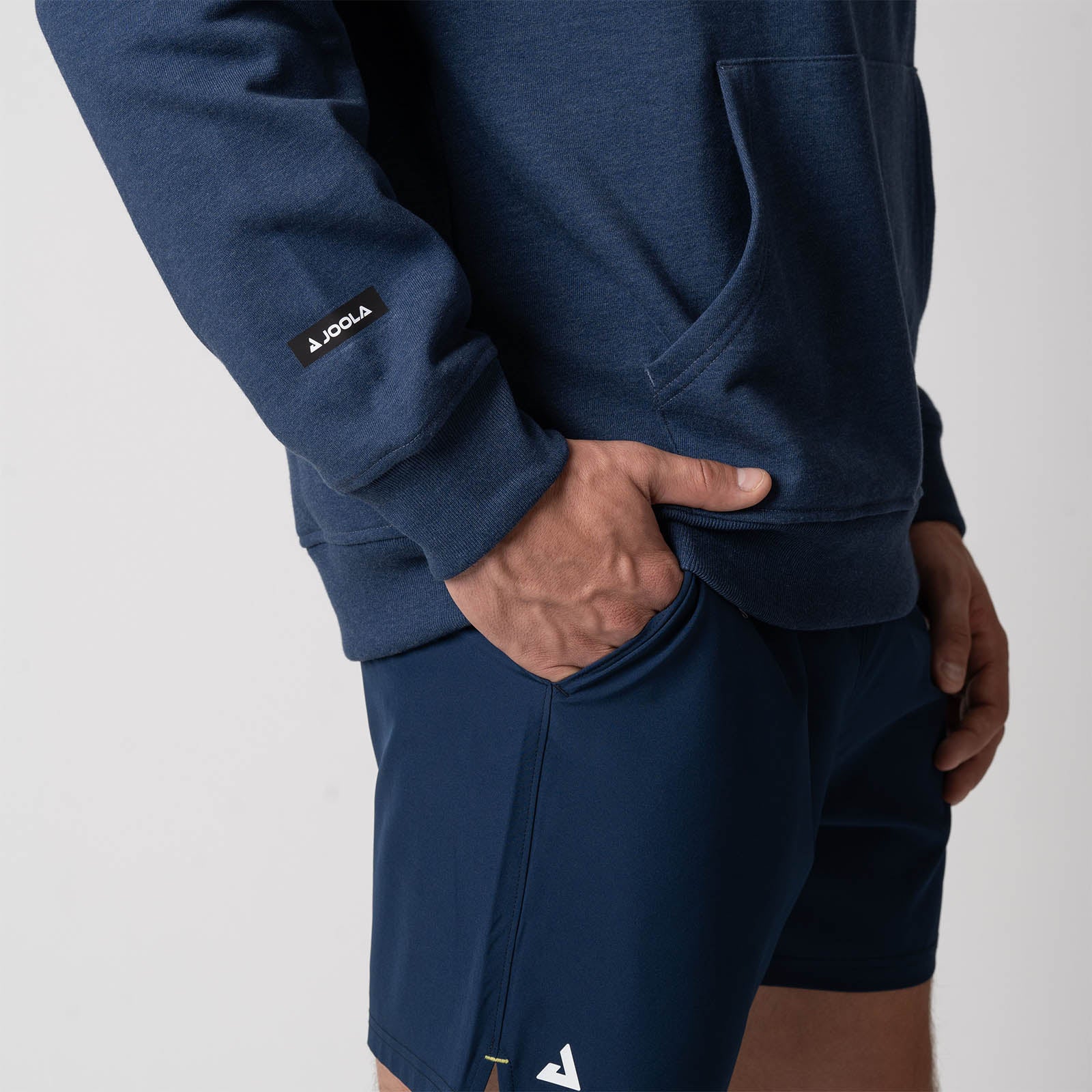 Close up image showing the JOOLA Logo on the right sleeve of the JOOLA Unisex Fleece Hoodie, Navy.