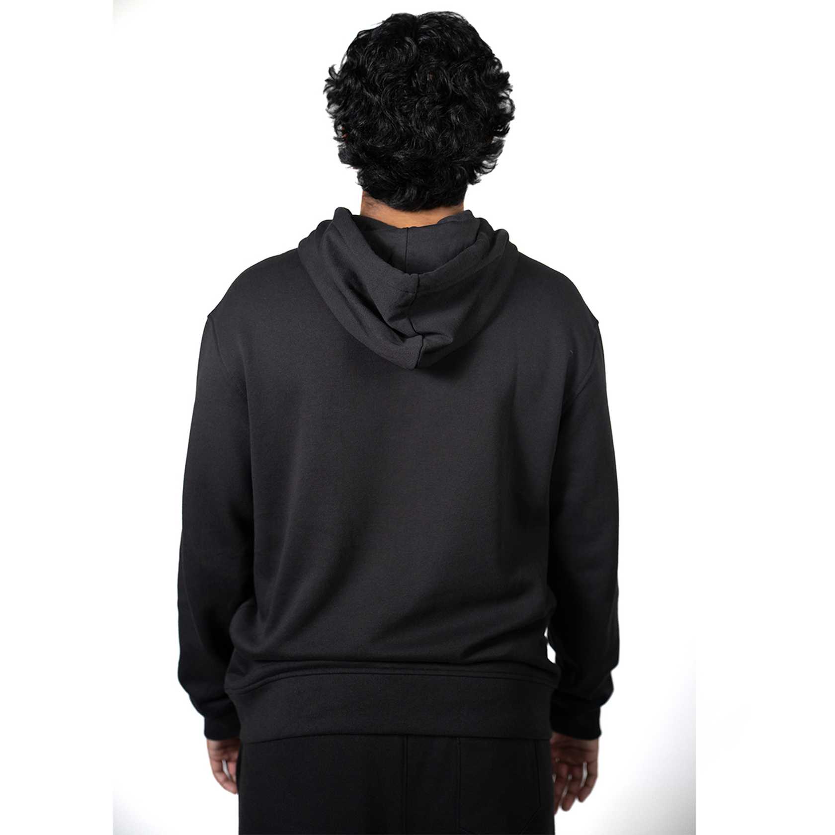 Person wearing a black hoodie from behind on a white background.