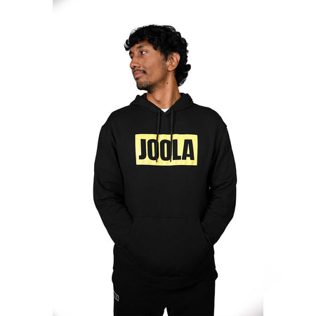 Person wearing a black hoodie with 'JOOLA' logo on a white background