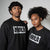 Two people wearing black fleece JOOLA sweatshirts with a brand logo on a gray background