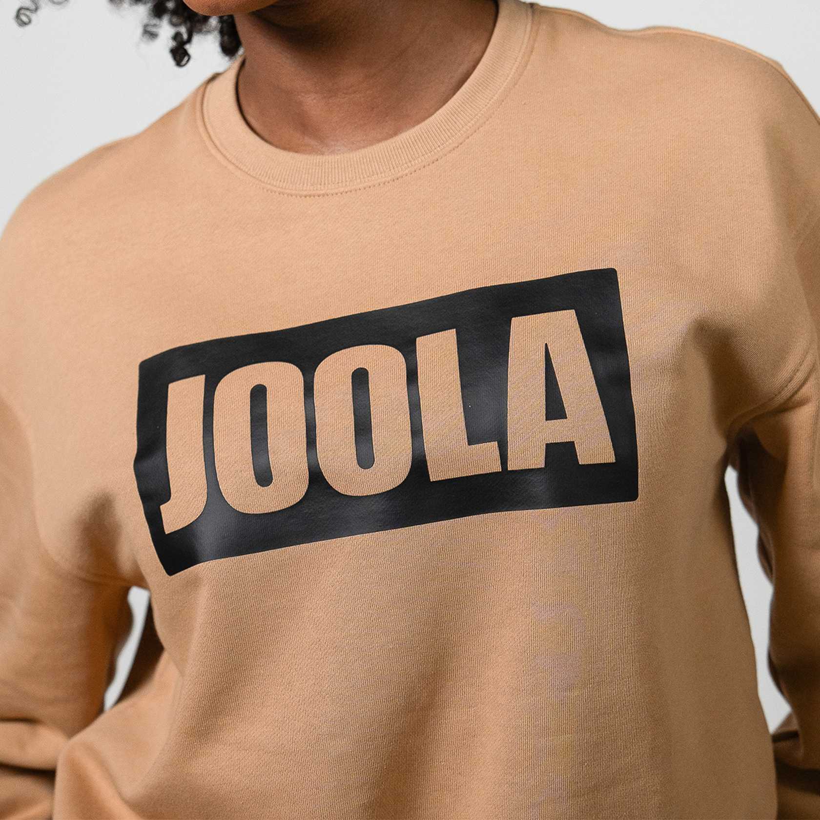 Close up of the JOOLA logo on a Latte Colored Fleece Sweatshirt.