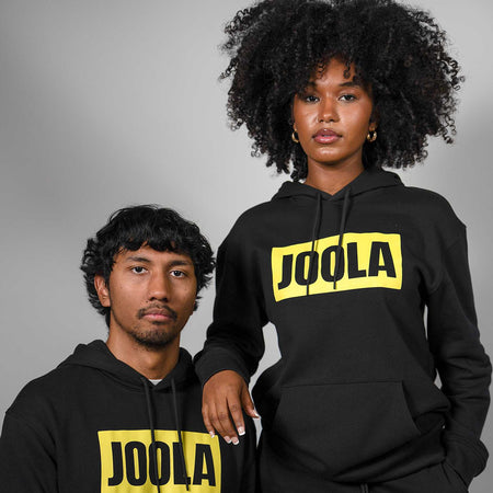 Two people wearing black hoodies with 'JOOLA' logo on a gray background