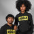 Two people wearing black hoodies with 'JOOLA' logo on a gray background
