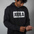 Person wearing a black hoodie with 'JOOLA' logo on a gray background