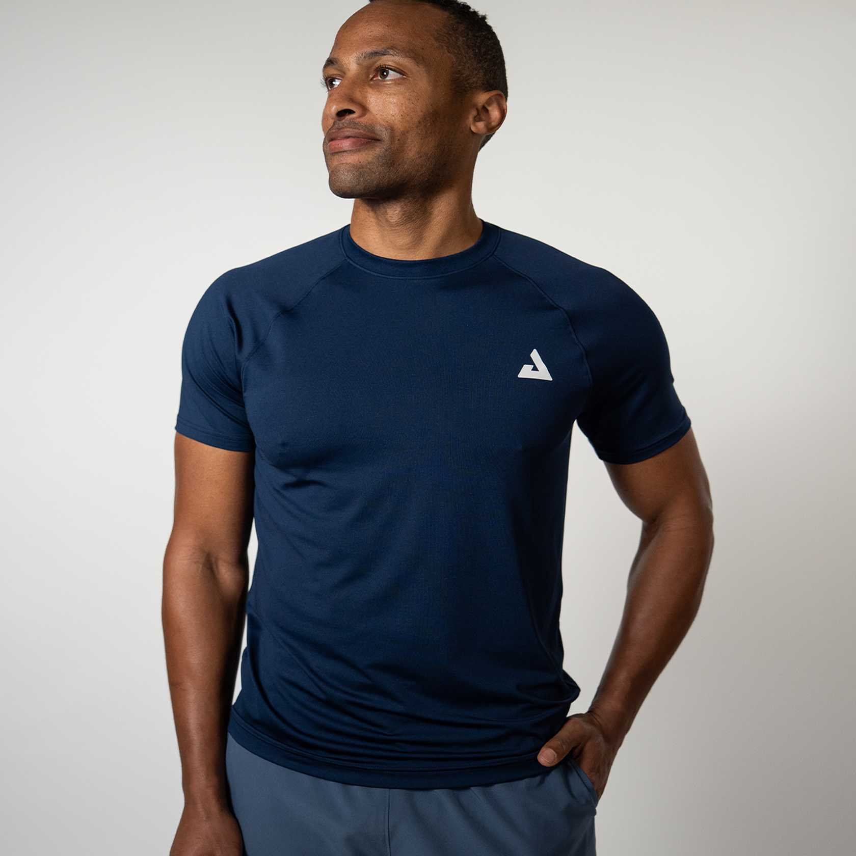 Man wearing a navy blue athletic shirt with a JOOLA Trinity logo on a light gray background