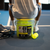 Person sitting on a bucket of JOOLA HC-40 pickleballs.