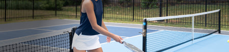 Header image for the JOOLA women's apparel collection. A female model is shown holding a JOOLA pickleball paddle.