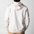 Gray background, the back of a white and latte colored JOOLA zip up hoodie.