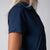 Close up image showing the JOOLA logo tag on the right sleeve of a JOOLA Women's Club Polo Dress, Navy.