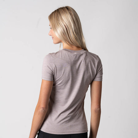 Image showing the back of a female model who is wearing the JOOLA Women's Club Short Sleeve Shirt, Dusty Mauve Heather.