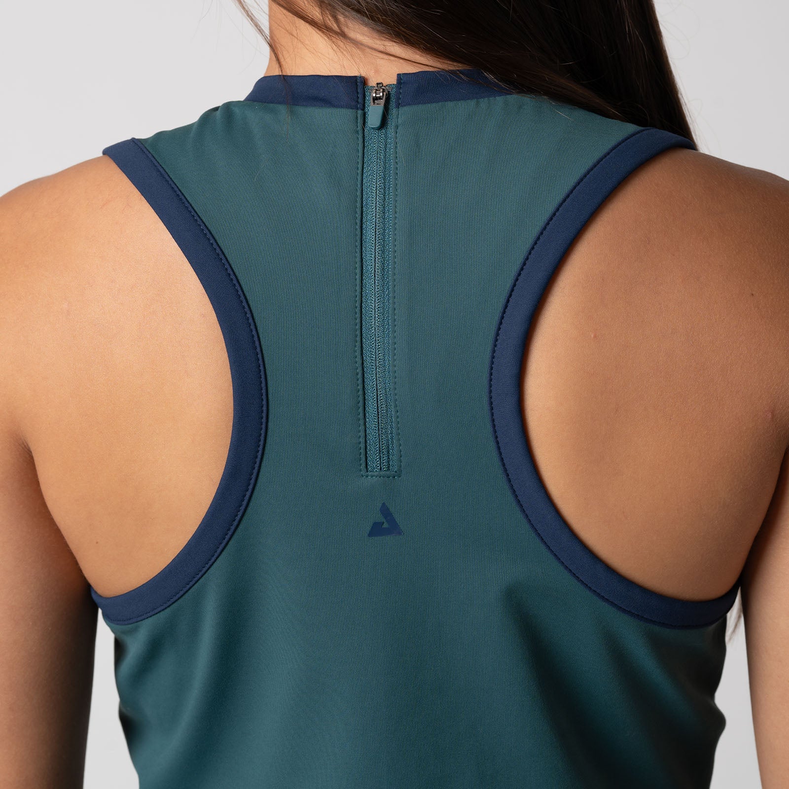 Close up image showing the detailed back zipper and JOOLA trinity logo design on the back of a JOOLA Women's Court Dress. Club Green.