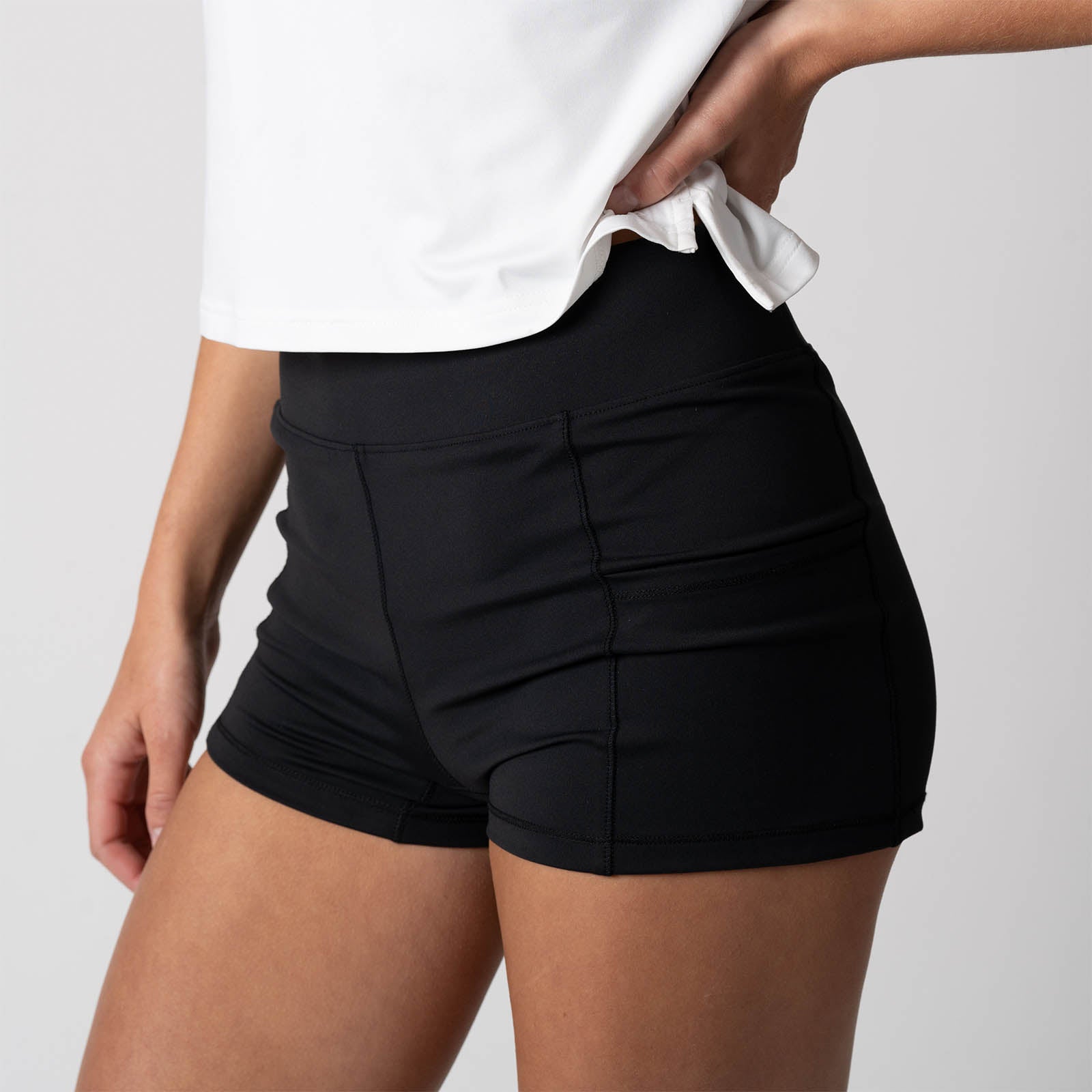 Close up view of a female model posing in a pair of JOOLA Women's Knit Shorty shorts, black.