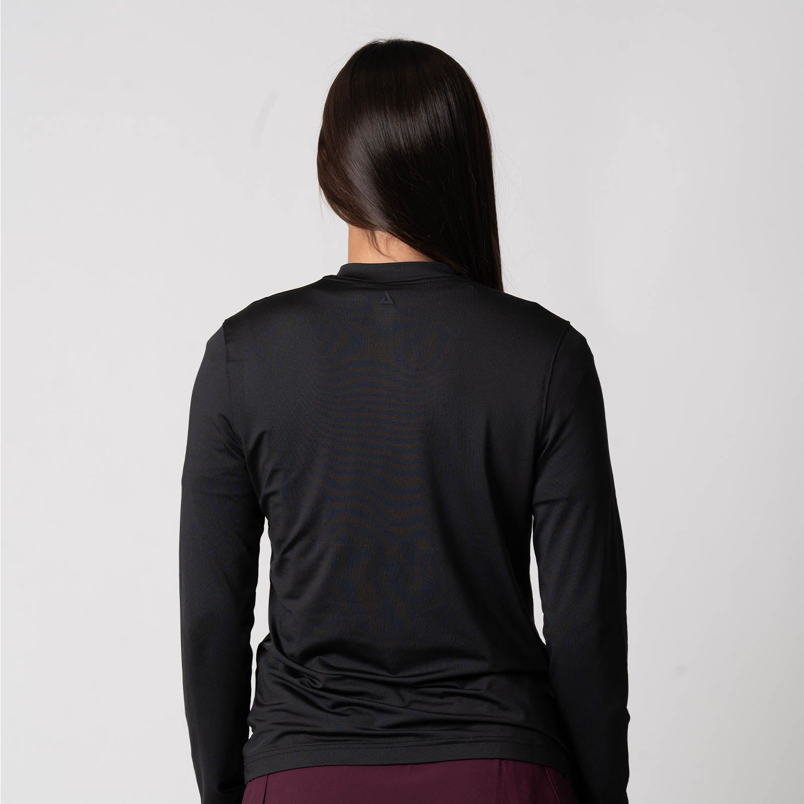 Image showing the back of a female model who is wearing the JOOLA Women's Quarter Zip Pullover, Black.