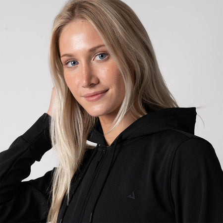 Close up image of a female model wearing a JOOLA Women's Ribbed Jacket, black.