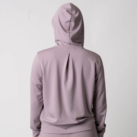 Image showing the back of a female model who is wearing a JOOLA Women's Ribbed Jacket, Dusty Mauve.