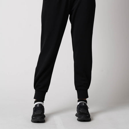 Image showing the lower half of a female models body, she is posing in a pair of JOOLA Women's Ribbed Joggers, black.