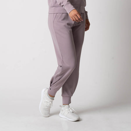 Image showing the bottom half of a female model who is wearing a pair of JOOLA Women's Ribbed Joggers, Dusty Mauve.