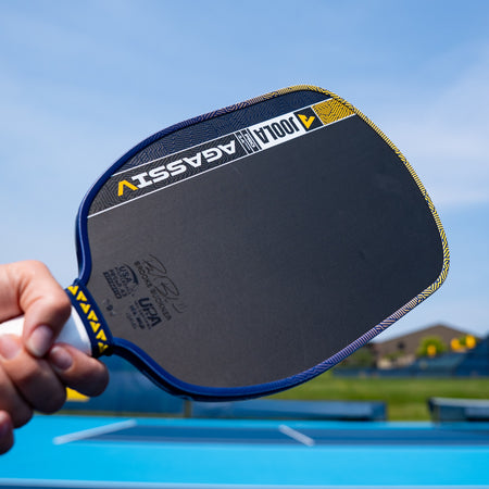 Image of a person holding a JOOLA Dual Signature Kate Fahey and Brooke Buckner Agassi Pro V pickleball paddle.