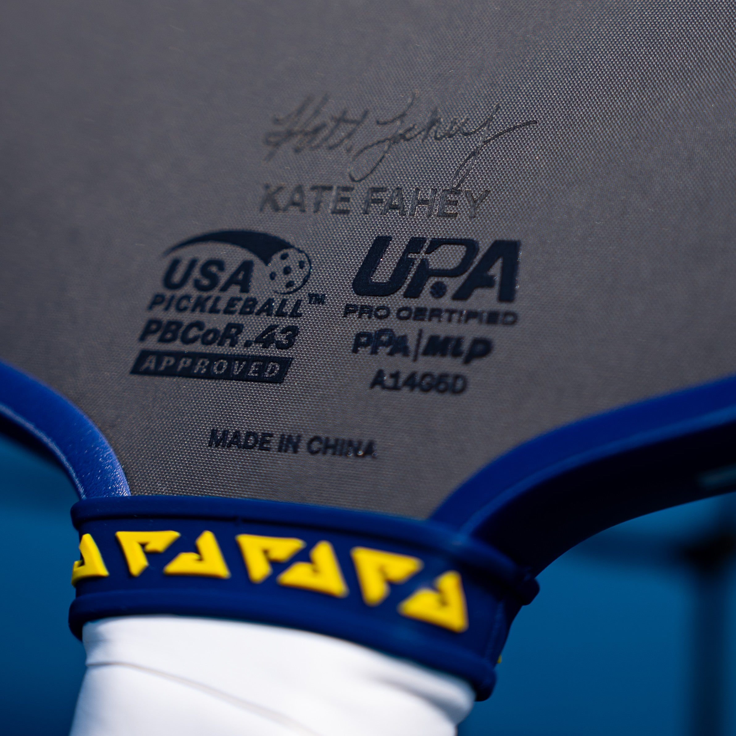 Close up on the signature of Kate Fahey and the dual certification stamps on the face of the agassi pro.