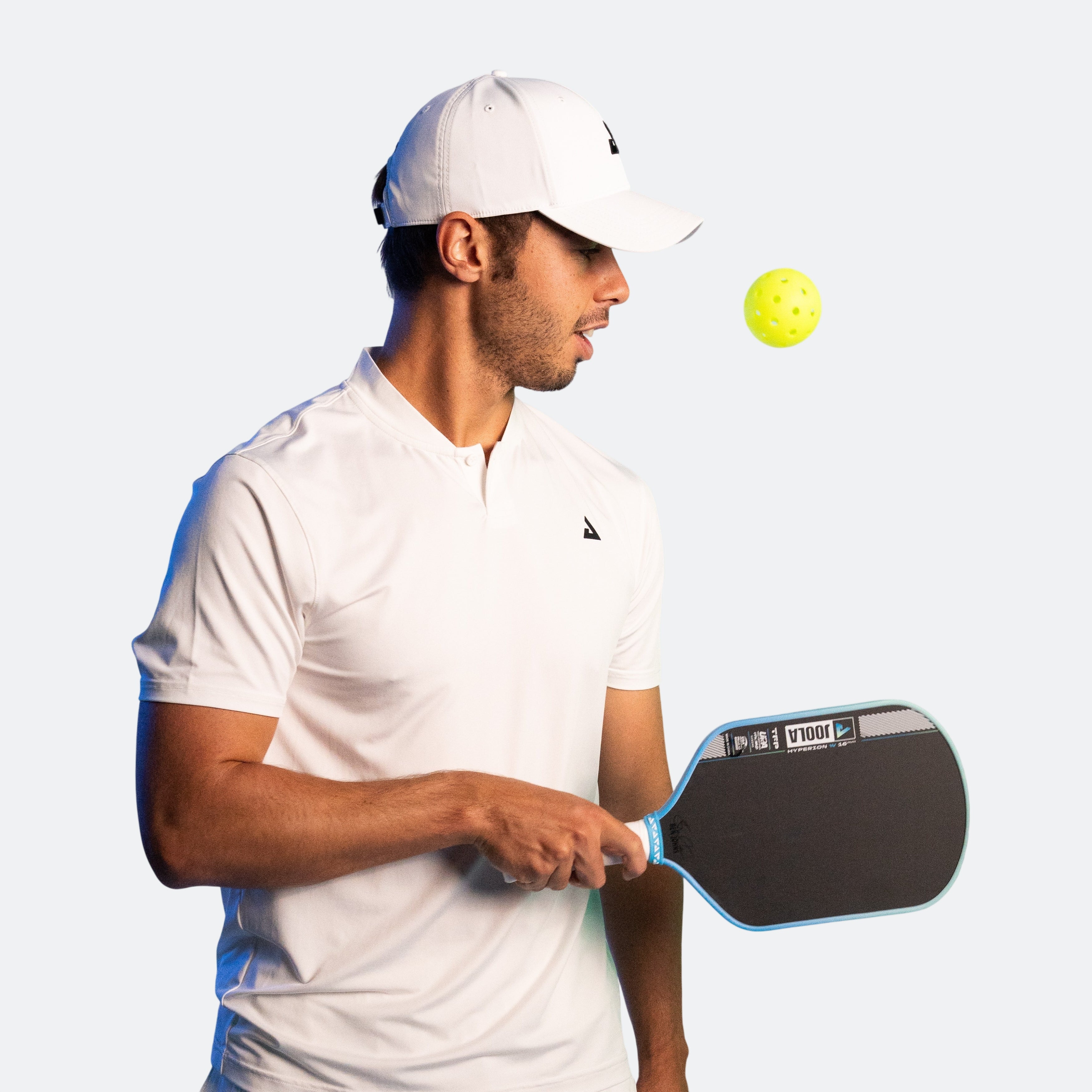 Image of JOOLA Pro Ben John's with pickleball in the air, holding a JOOLA Hyperion Pro IV pickleball paddle.