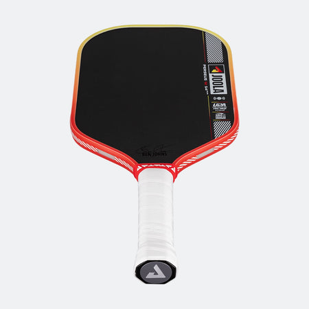 Pickleball paddle with black playing surface, red and white handle, and visible branding on a white background