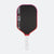 Pickleball paddle with black surface, red border, and white handle on a white background
