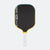 Pickleball paddle with black paddle face, yellow rim, and white handle on a white background.