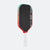 Pickleball paddle with black face, red sides, and white handle on a white background