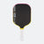 Pickleball paddle with black surface, yellow rim, and white handle on a white background.