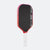 Pickleball paddle with black surface, red edges, and white handle on a white background