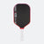 Pickleball paddle with black surface, red border, and white handle on a white background