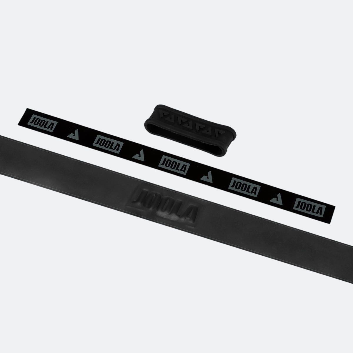 White background, image of black JOOLA Fel-Tec Pure Grip unrolled with a black JOOLA rubber band pictured.